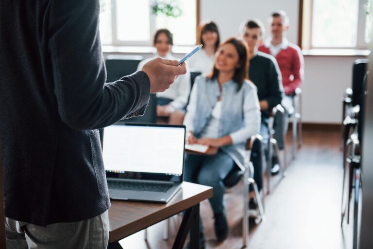 everyone-is-smiling-listens-group-people-business-conference-modern-classroom-daytime-min